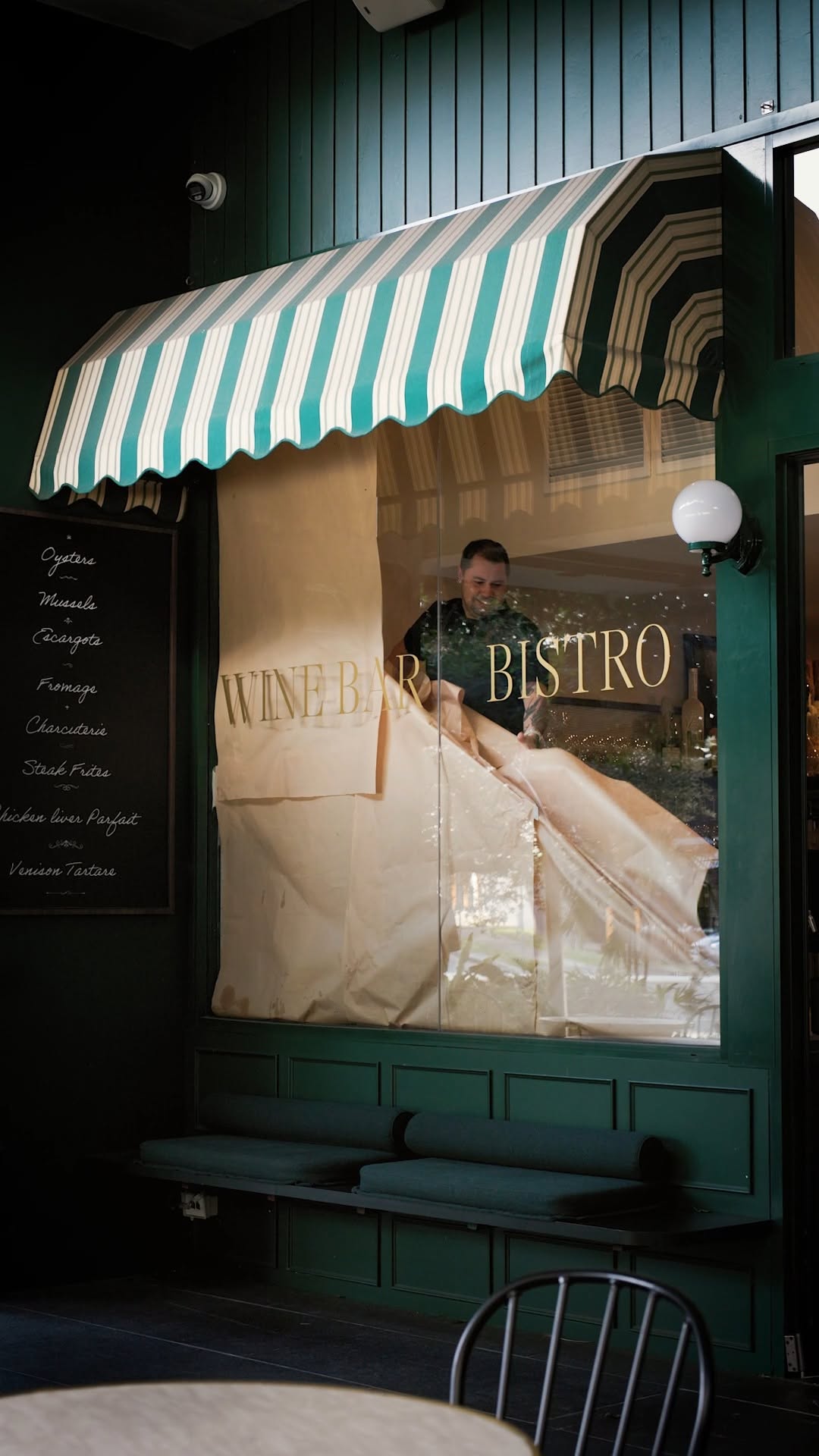 The emerald green South City Wine storefront and striped awning